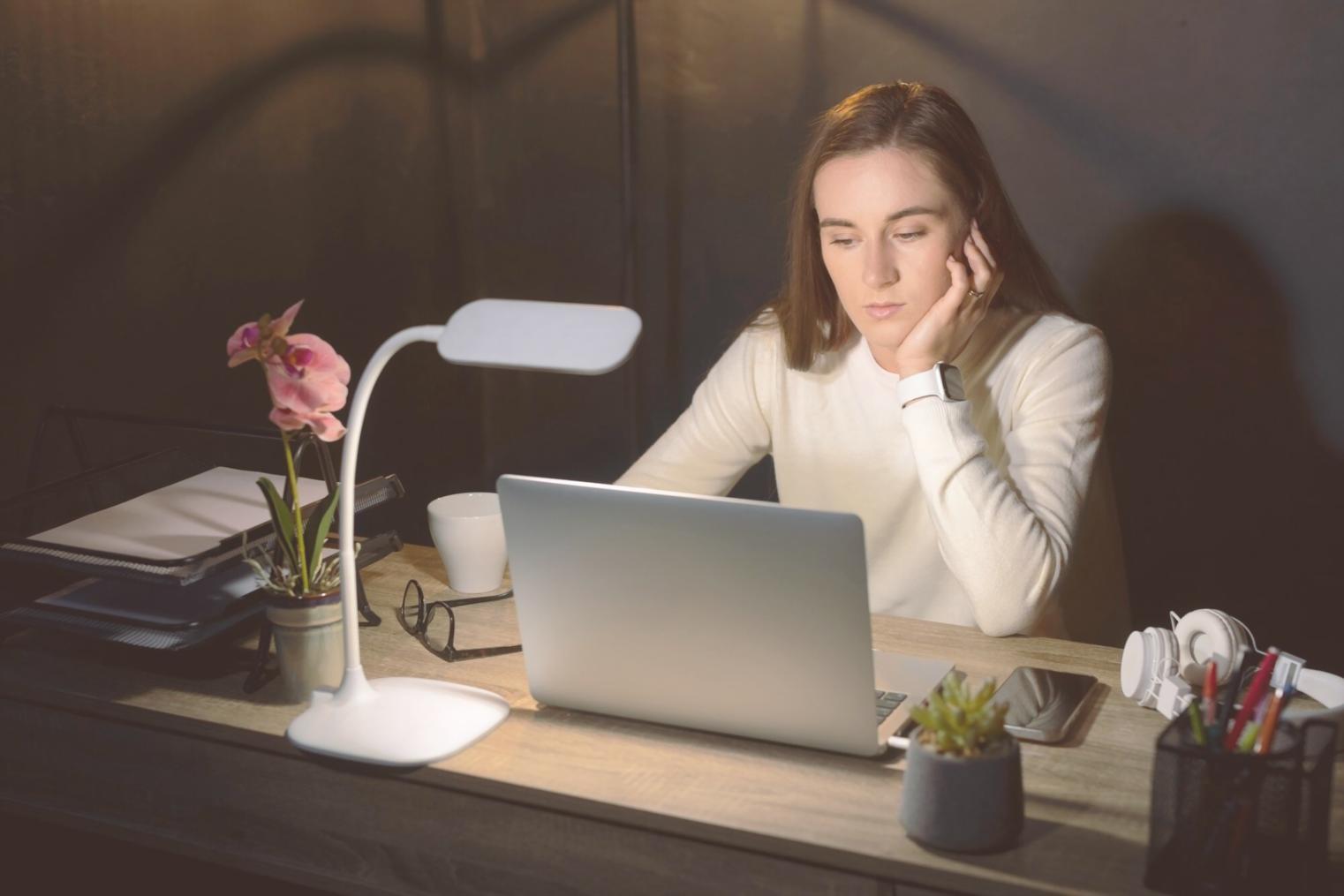 Person beim Durchgehen von Finanzunterlagen am Schreibtisch